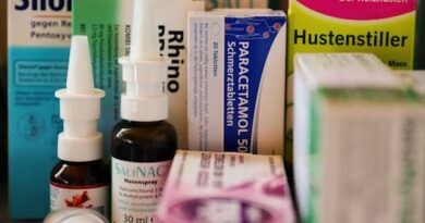 Assortment of cold and flu medications on a pharmacy counter.