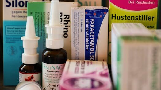 Assortment of cold and flu medications on a pharmacy counter.